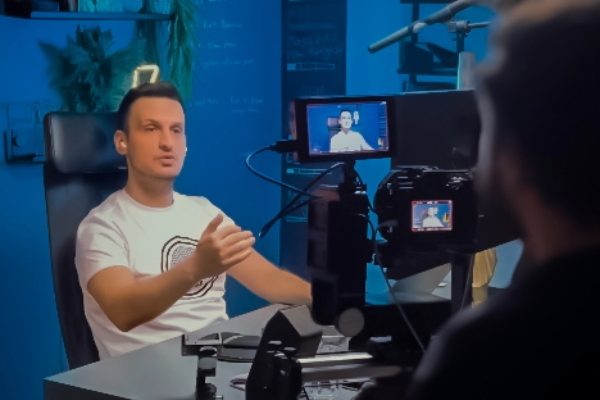 Kameraya anlatım yapan erkek eğitmen, video içerik kaydı sırasında